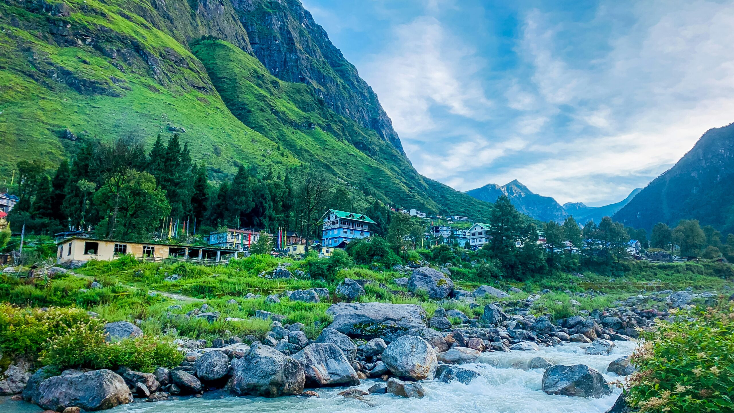 Mountain village with river and rocky stream surrounded by green hills in North Bengal.