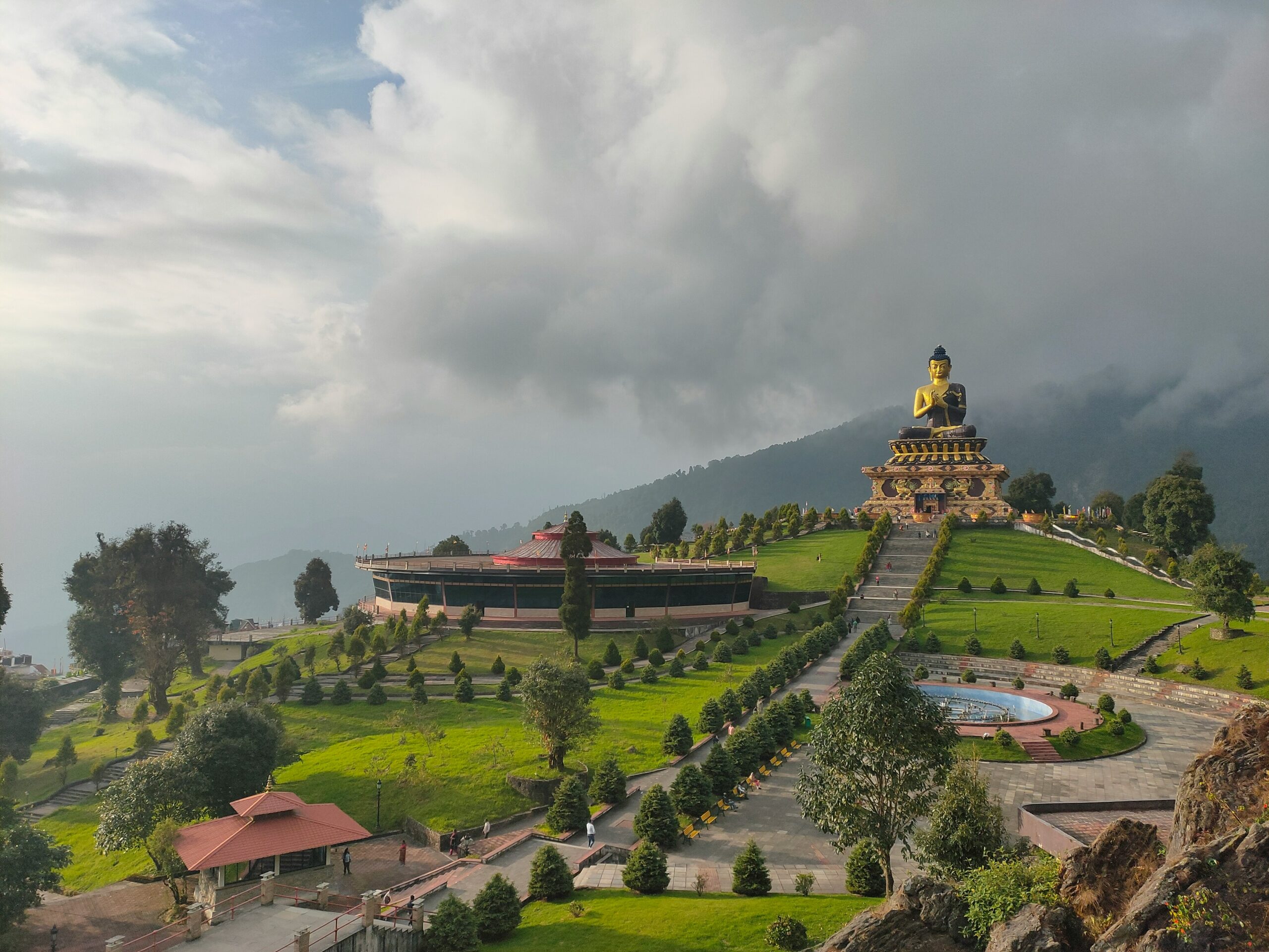 Giant Buddha statue at Buddha Park Ravangla surrounded by lush green landscape in Sikkim.